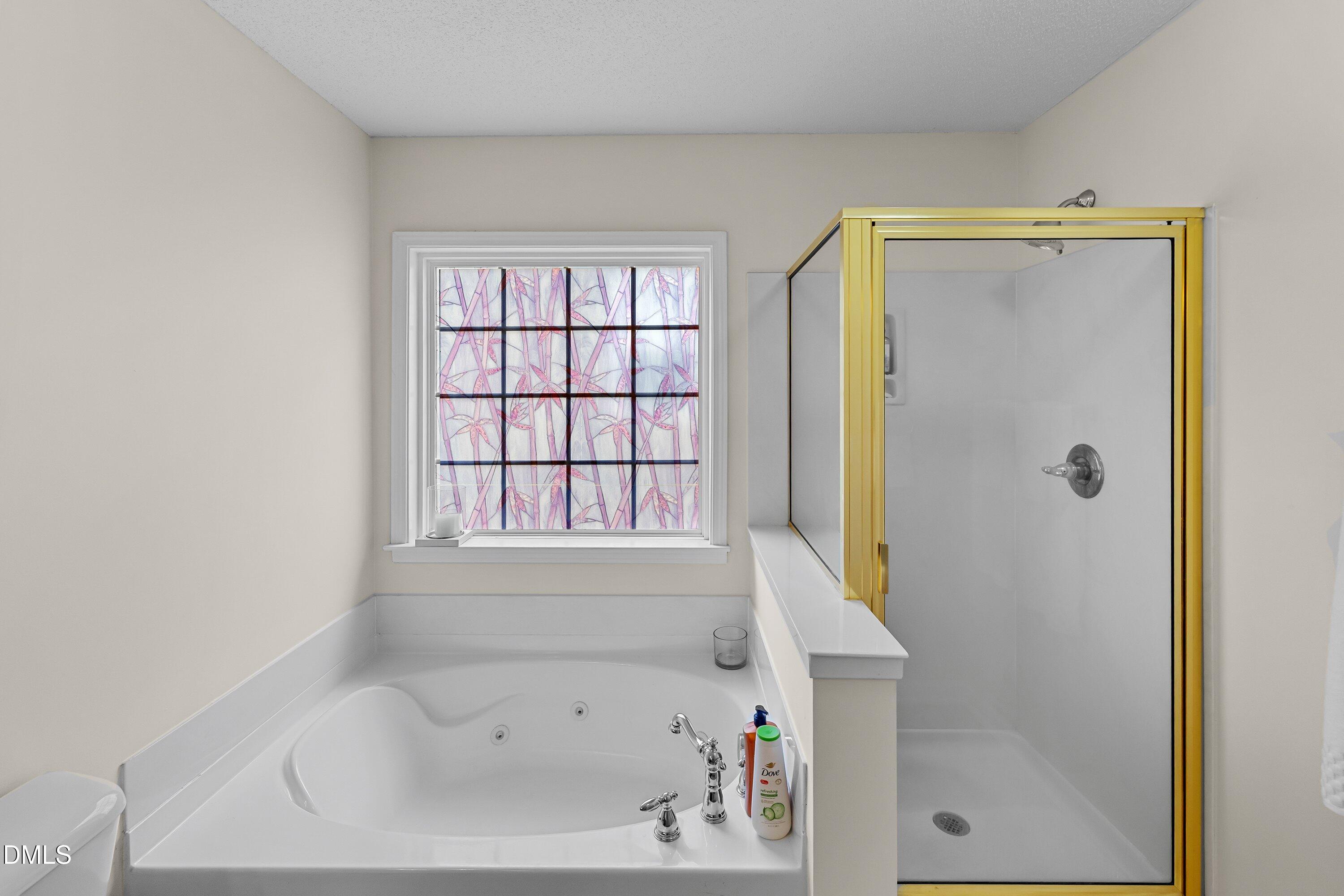 8911 Elizabeth Benneth Place Raleigh, NC 27616 - Photo 17 of 31 a bathroom with a bathtub and a shower