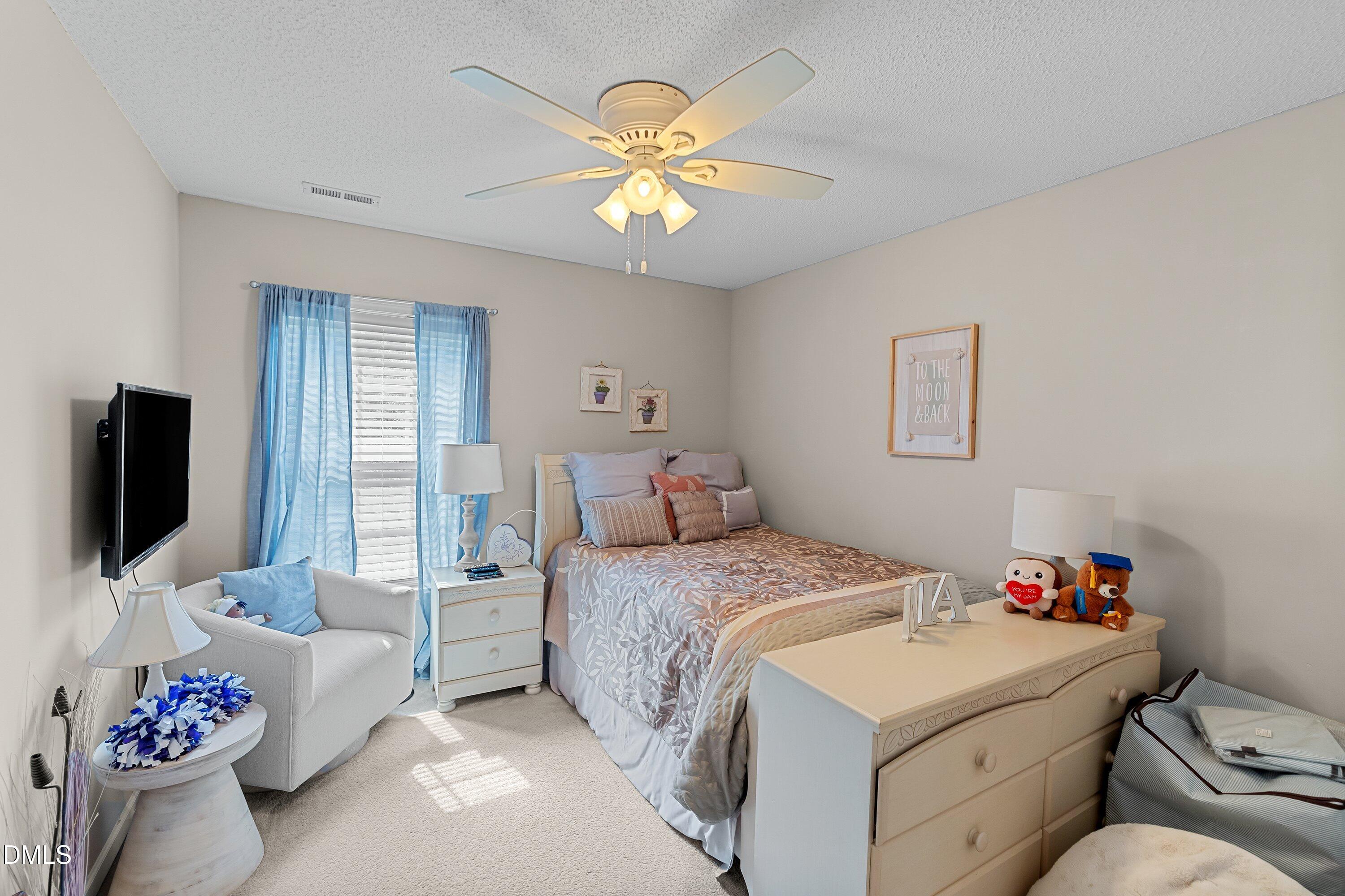 8911 Elizabeth Benneth Place Raleigh, NC 27616 - Photo 18 of 31 a bedroom with a bed and a flat screen tv