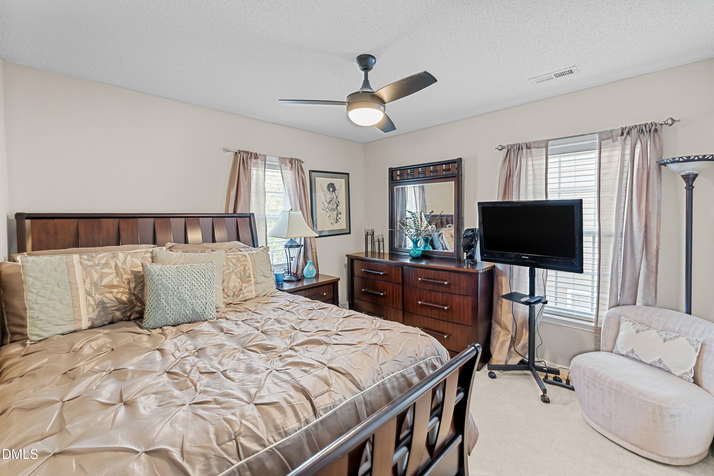 8911 Elizabeth Benneth Place Raleigh, NC 27616 - Photo 19 of 31 a bedroom with a bed and a flat screen tv