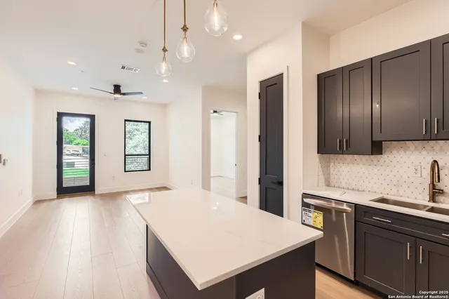 a kitchen with a sink a counter top space stainless steel appliances and cabinets
