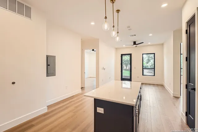 a view of an empty room with window and wooden floor