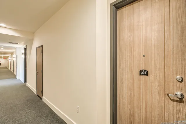 a view of a hallway with wooden floor