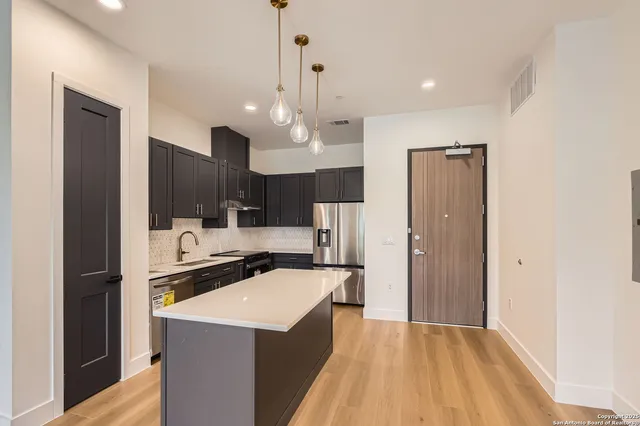 a kitchen with stainless steel appliances a sink stove and refrigerator