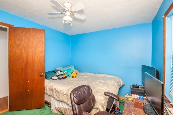 789 Boston Road Billerica, MA 01821 - Photo 6 of 23 a bedroom with a bed and a chandelier fan