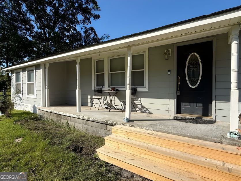 19963 Highway 46 Pembroke, GA 31321 - Photo 2 of 17 a front view of a house with garden and porch