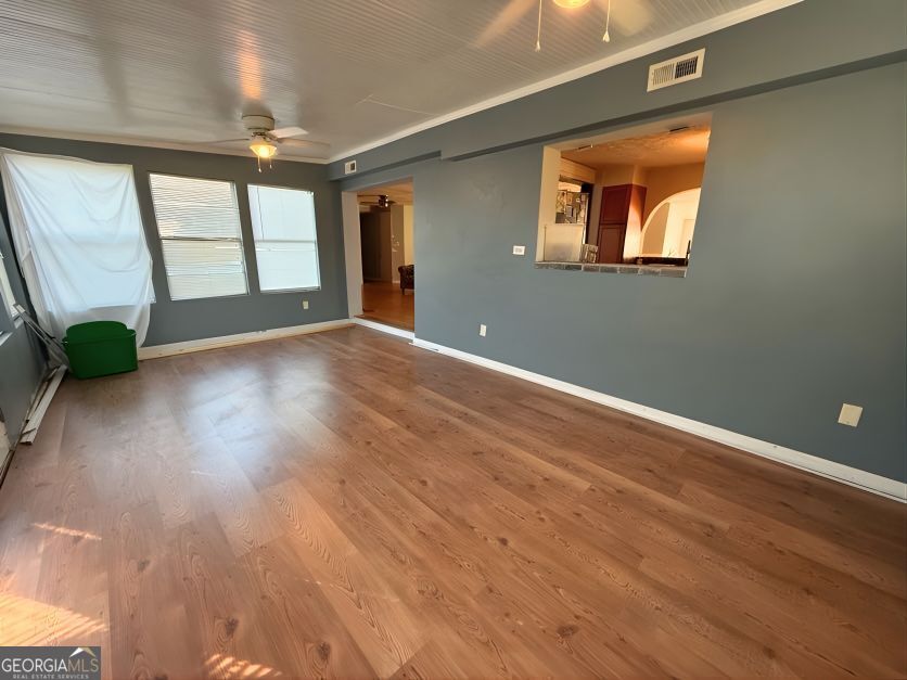 19963 Highway 46 Pembroke, GA 31321 - Photo 10 of 17 an empty room with wooden floor and windows