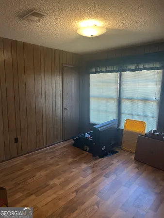 a view of room with kitchen island stainless steel appliances wooden floor and window