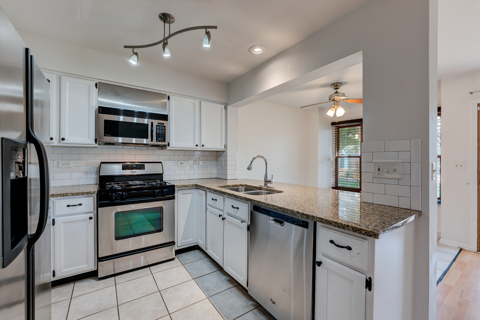 298 Ripplebrook Court Schaumburg, IL 60173 - Photo 11 of 27 a kitchen with stainless steel appliances granite countertop a stove a sink and a microwave