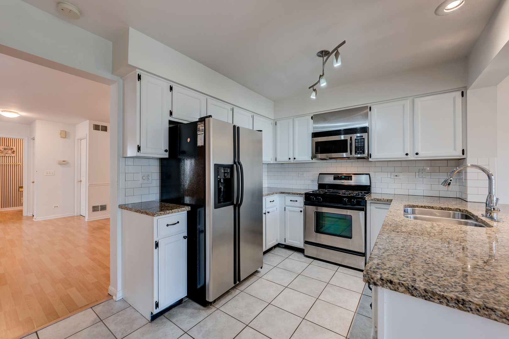 298 Ripplebrook Court Schaumburg, IL 60173 - Photo 10 of 27 a kitchen with granite countertop a refrigerator and a sink