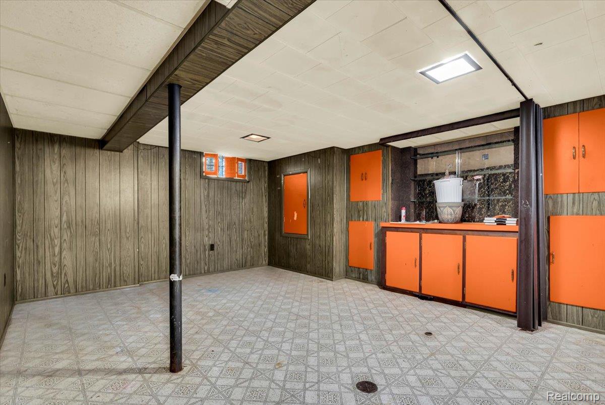 1215 Center Street Inkster, MI 48141 - Photo 20 of 30 Wood-finish wall paneling, patterned flooring, recessed lighting, and built-in cabinetry with orange cabinet faces
