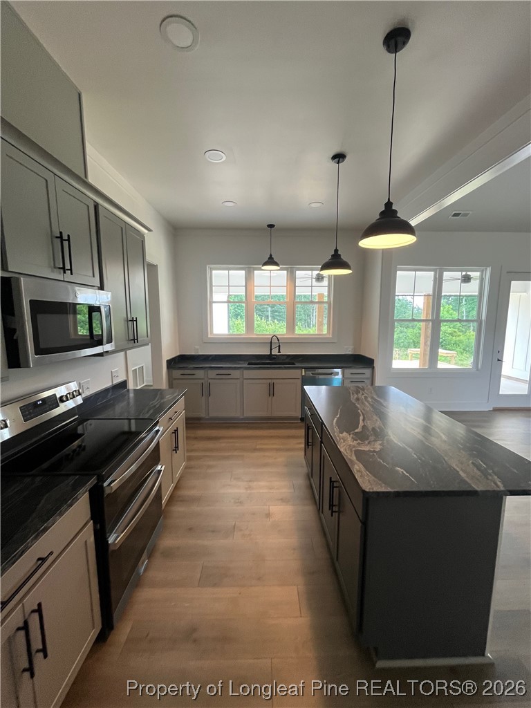 115 Keyser Street Aberdeen, NC 28315 - Photo 8 of 17 a kitchen with stainless steel appliances granite countertop a sink a stove and a wooden floor