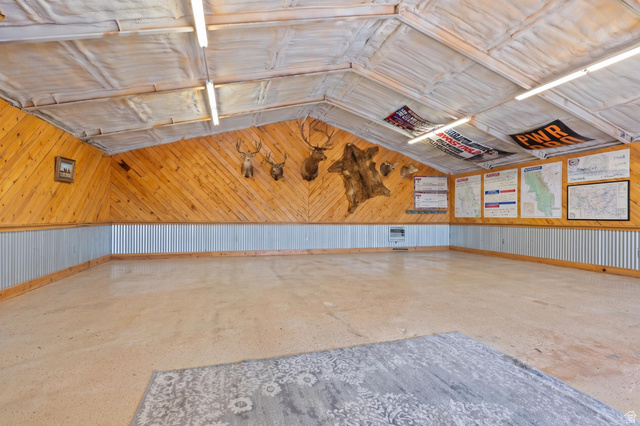 115 East 1600th Street North Santaquin, UT 84655 - Photo 44 of 52 Spacious interior featuring a vaulted ceiling with exposed insulation, wood-paneled walls, and corrugated metal wainscoting