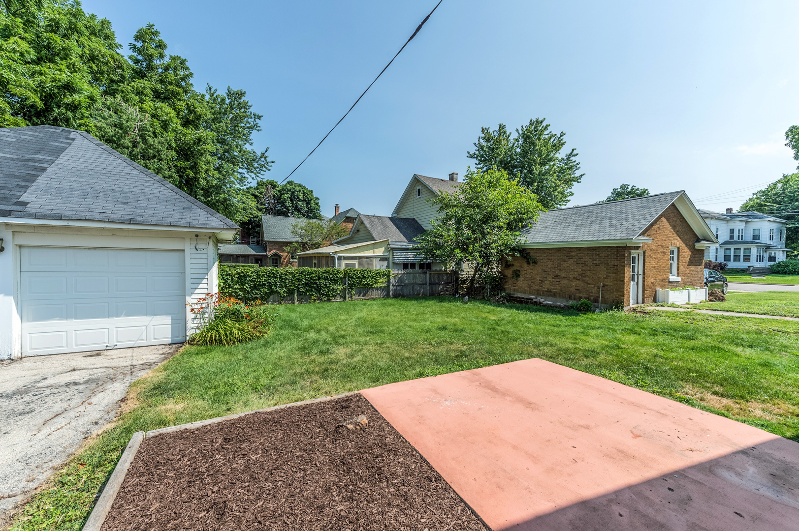209 West Exchange Street Sycamore, IL 60178 - Photo 23 of 25 a backyard of a house with plants and large trees