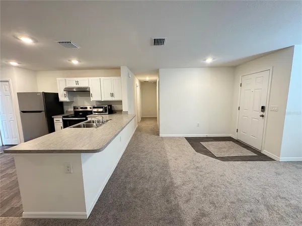 a kitchen with stainless steel appliances granite countertop a sink stove and a refrigerator