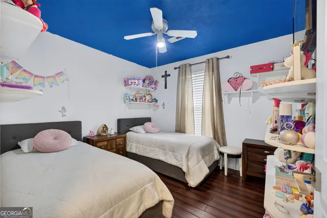 a bedroom with two beds and a ceiling fan
