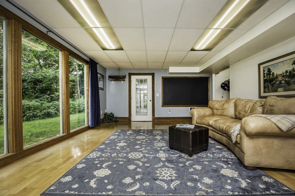 57 Oak Ridge Road Boxford, MA 01921 - Photo 19 of 30 a living room with furniture a flat screen tv and a floor to ceiling window
