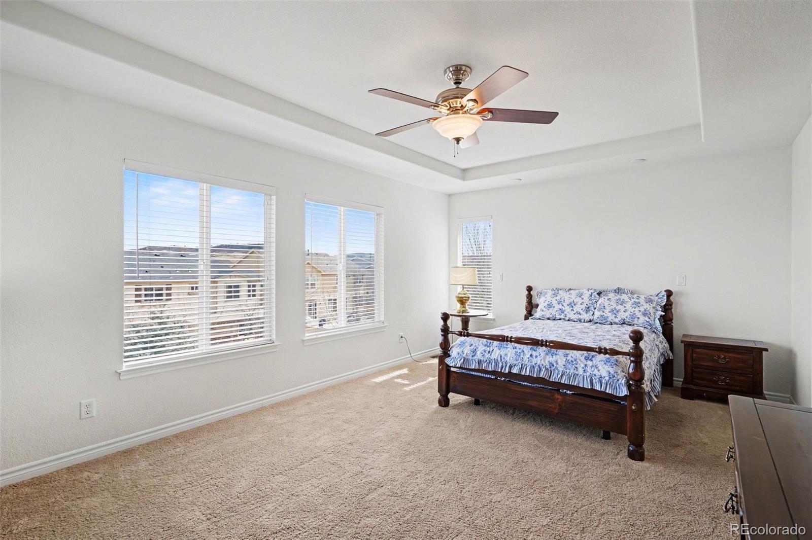 10844 Huntwick Street Highlands Ranch, CO 80130 - Photo 12 of 29 a spacious bedroom with a bed and a chandelier