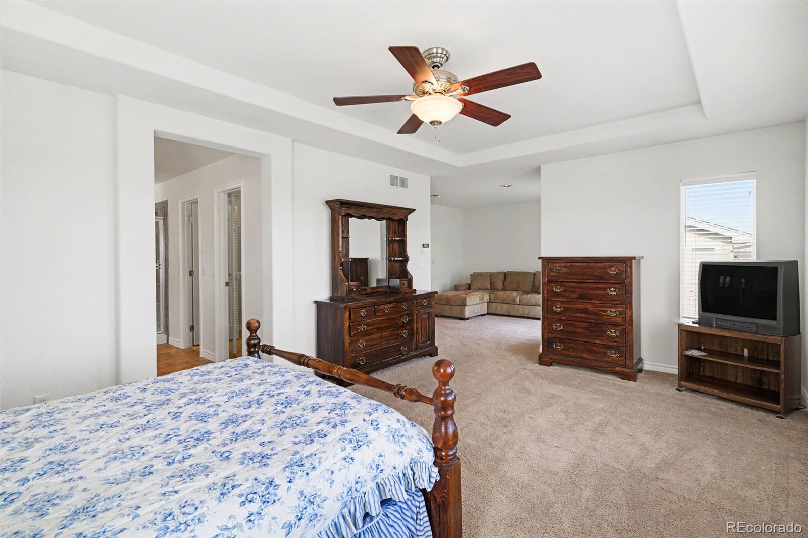 10844 Huntwick Street Highlands Ranch, CO 80130 - Photo 13 of 29 a bedroom with a bed and dresser with chair