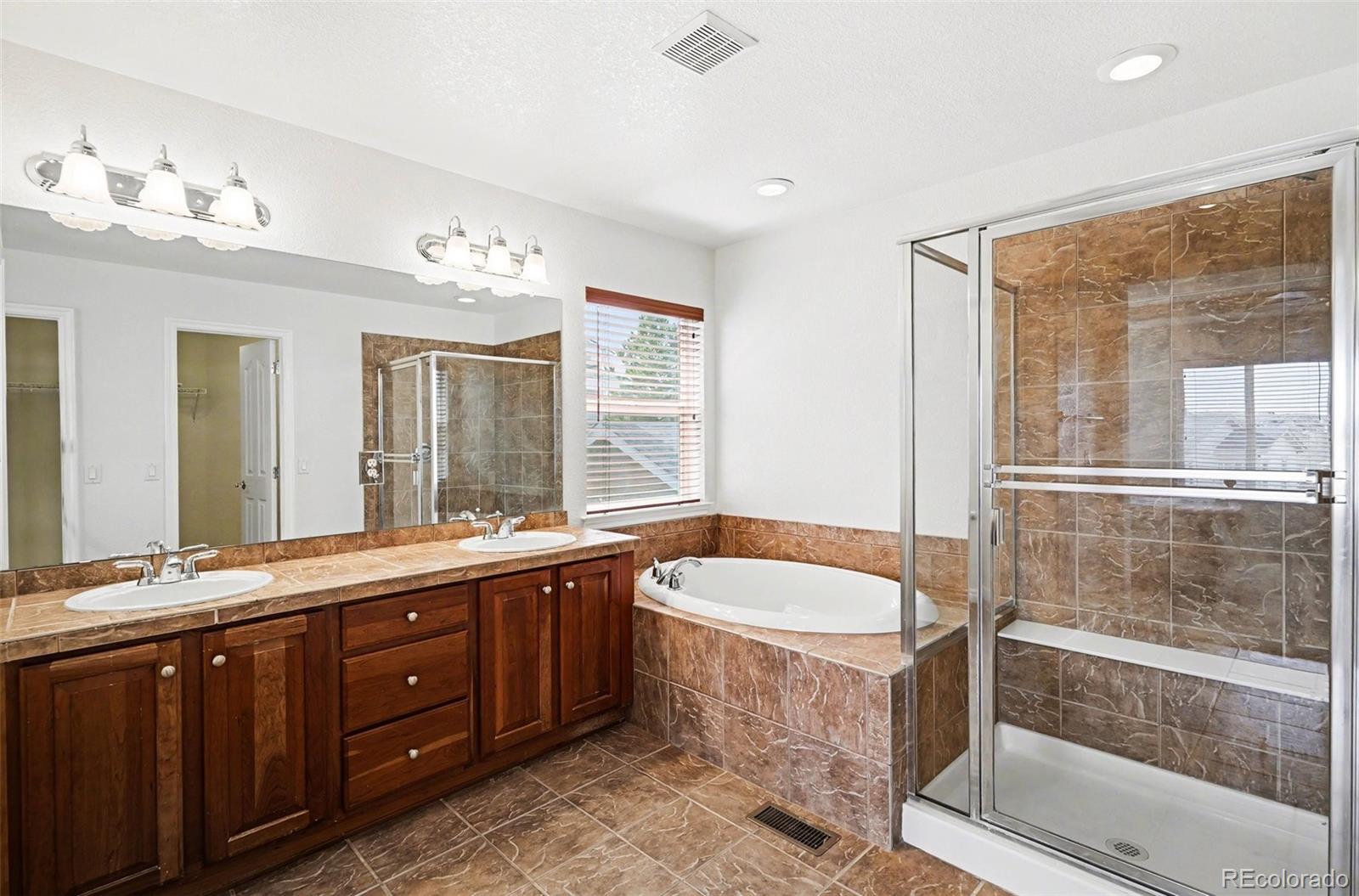 10844 Huntwick Street Highlands Ranch, CO 80130 - Photo 16 of 29 a bathroom with a bathtub double sink and mirror