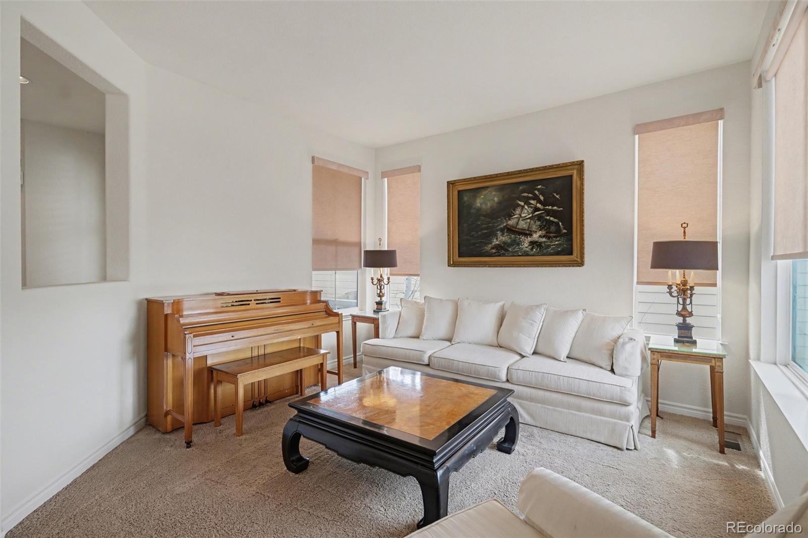 10844 Huntwick Street Highlands Ranch, CO 80130 - Photo 22 of 29 a living room with furniture a rug and a wall painting