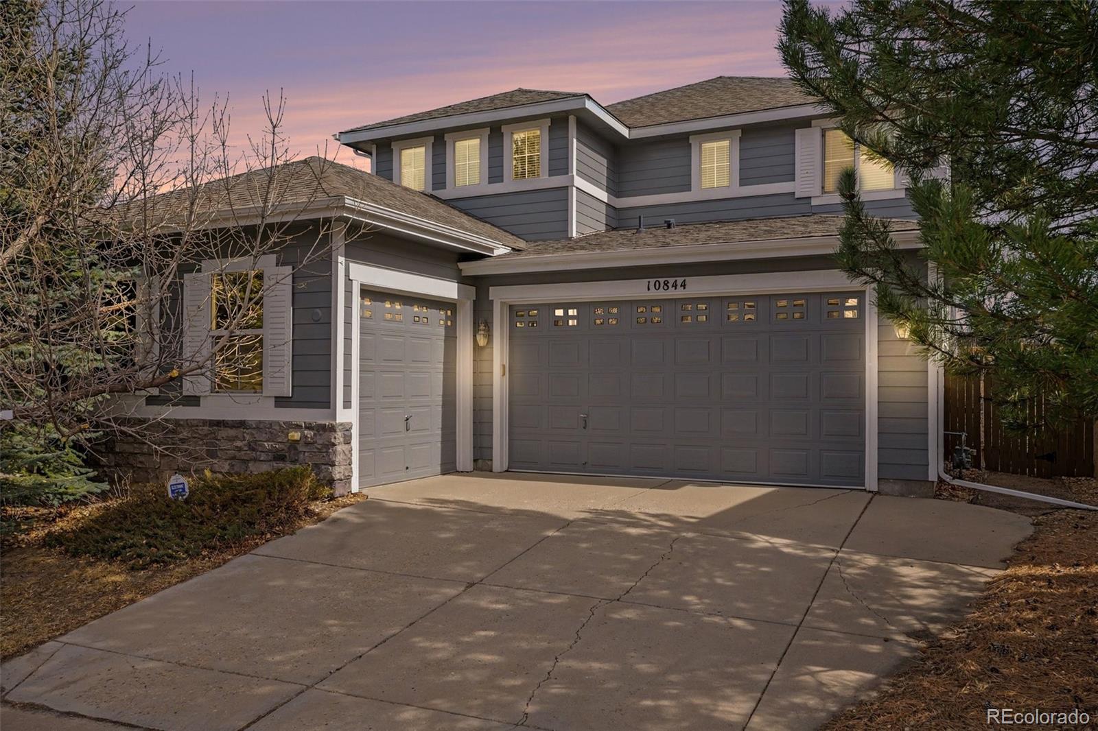 10844 Huntwick Street Highlands Ranch, CO 80130 - Photo 26 of 29 a front view of a house with a yard and garage