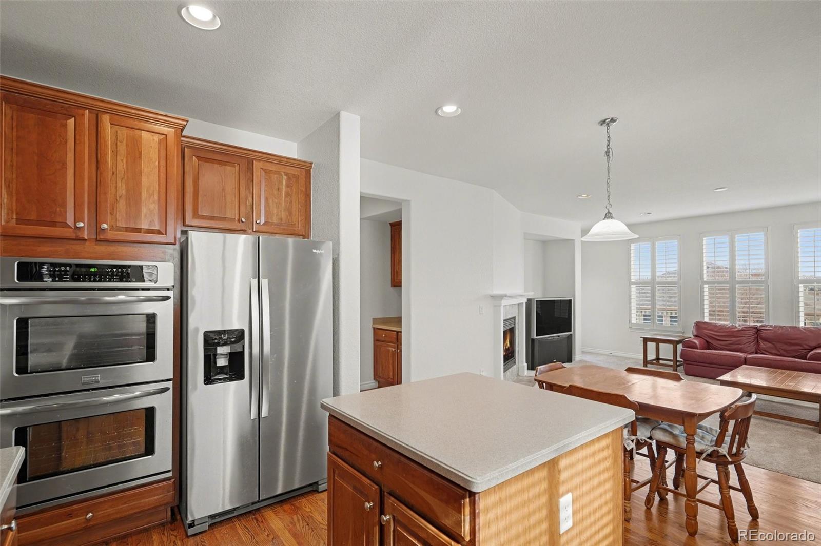 10844 Huntwick Street Highlands Ranch, CO 80130 - Photo 7 of 29 a kitchen with stainless steel appliances granite countertop a stove refrigerator and a view of living room