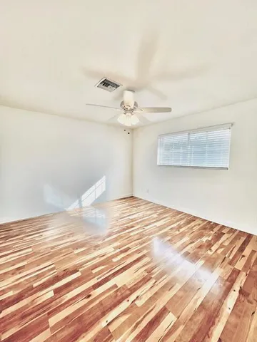 a view of a room with wooden floor and fan