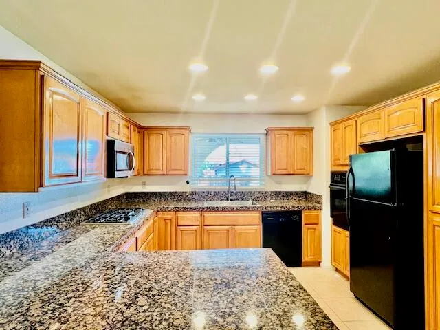 a kitchen with stainless steel appliances granite countertop a sink stove and refrigerator