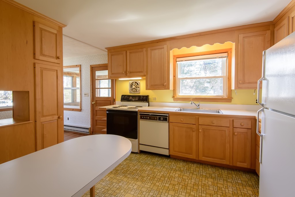 11 Dartmouth Road Marblehead, MA 01945 - Photo 12 of 25 a large kitchen with granite countertop a sink a stove a refrigerator a dining table and chairs with wooden floor
