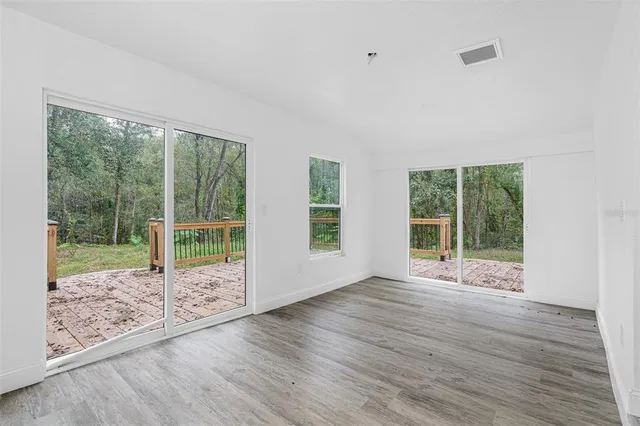 a view of a room with wooden floor and windows