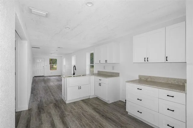 a kitchen with granite countertop white cabinets and white appliances