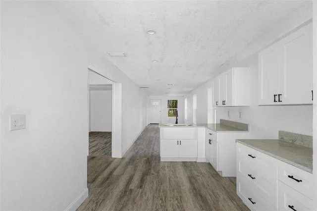 a kitchen with cabinets and wooden floor