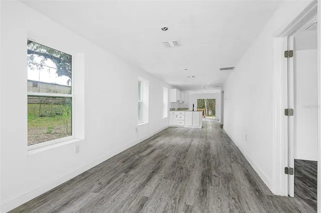 a view of a hallway with wooden floor and a window