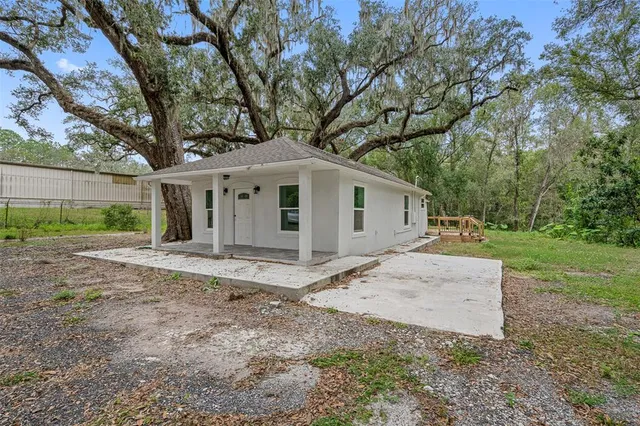 a view of a house with yard and a tree