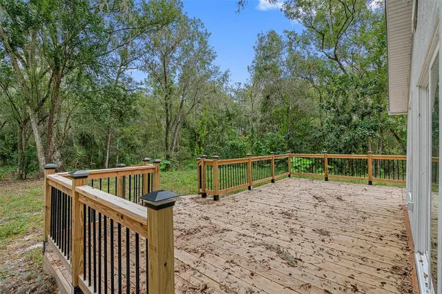 a view of deck with trees and wooden fence