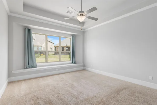 an empty room with a window and a ceiling fan