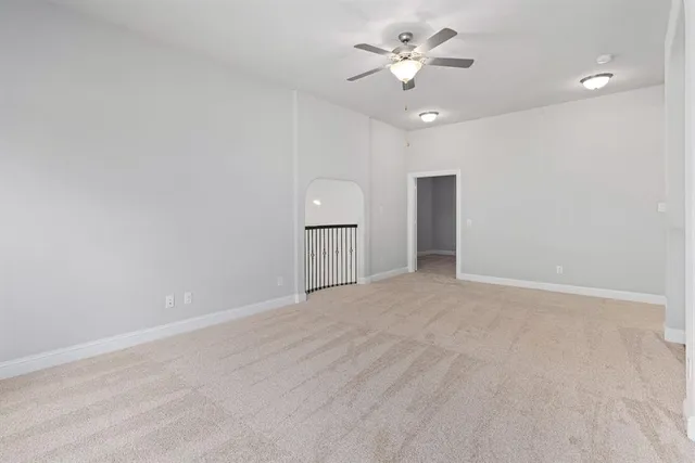 a view of an empty room with a ceiling fan