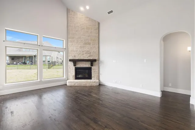 an empty room with wooden floor and fireplace