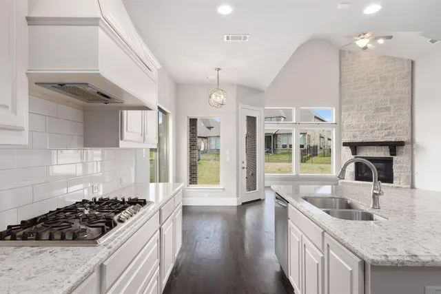a kitchen with stainless steel appliances a sink stove and cabinets