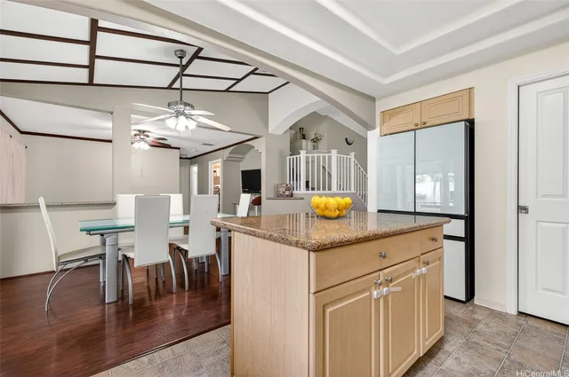 a kitchen with stainless steel appliances granite countertop a table chairs and a refrigerator