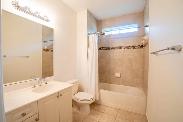 a bathroom with a bathtub shower sink vanity and toilet