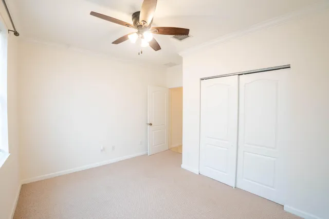 an empty room with a ceiling fan and a window