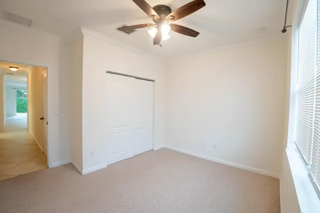 an empty room with a window and a ceiling fan