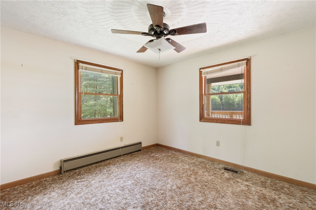258 Walnut Road Southwest Dellroy, OH 44620 - Photo 15 of 33 Bedroom with multiple windows, ceiling fan and carpet flooring