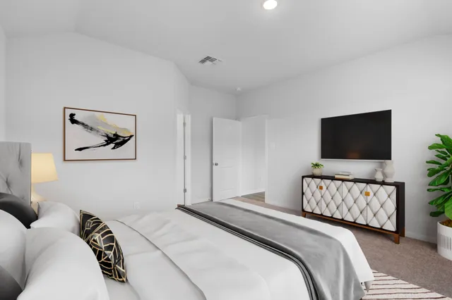 a bedroom with bed a plant and a window