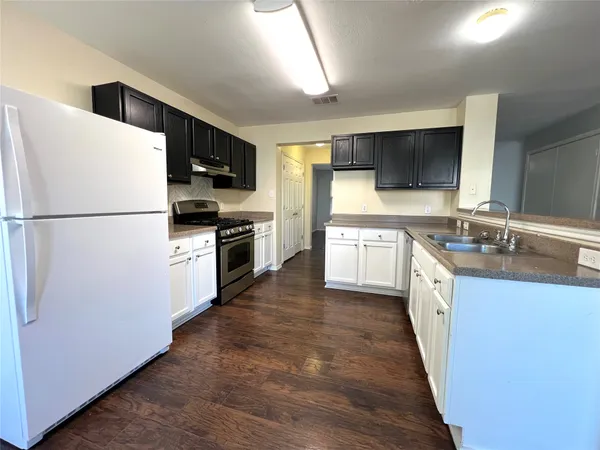 a kitchen with stainless steel appliances a refrigerator sink and stove