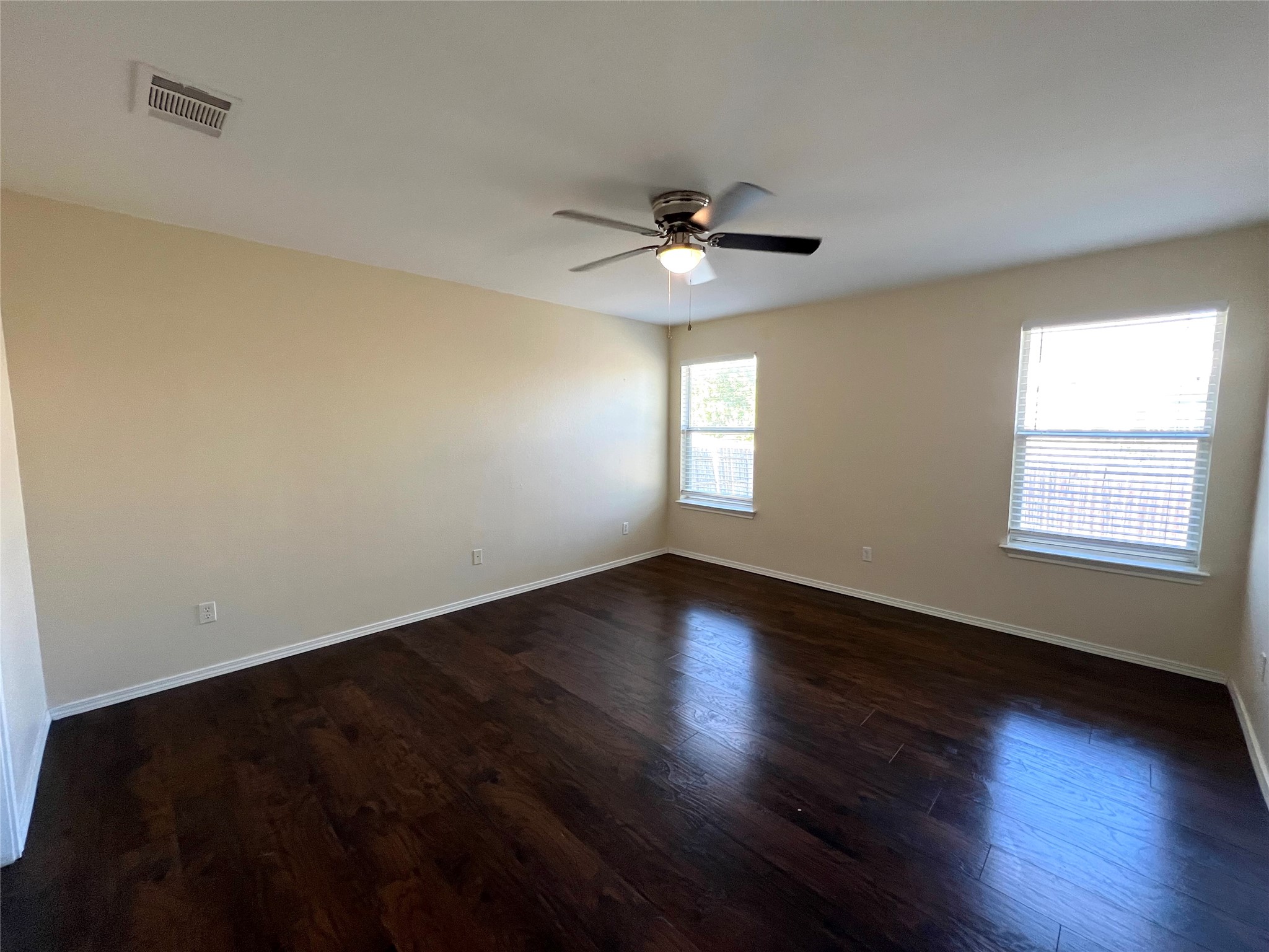 125 Dandelion Loop Kyle, TX 78640 - Photo 18 of 25 a view of an empty room with wooden floor and a window