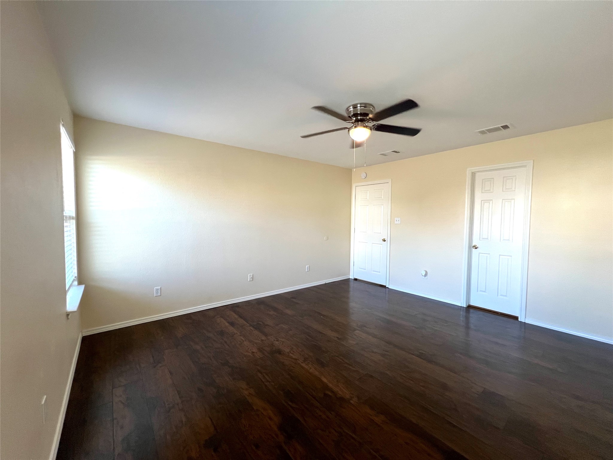 125 Dandelion Loop Kyle, TX 78640 - Photo 19 of 25 an empty room with wooden floor and windows