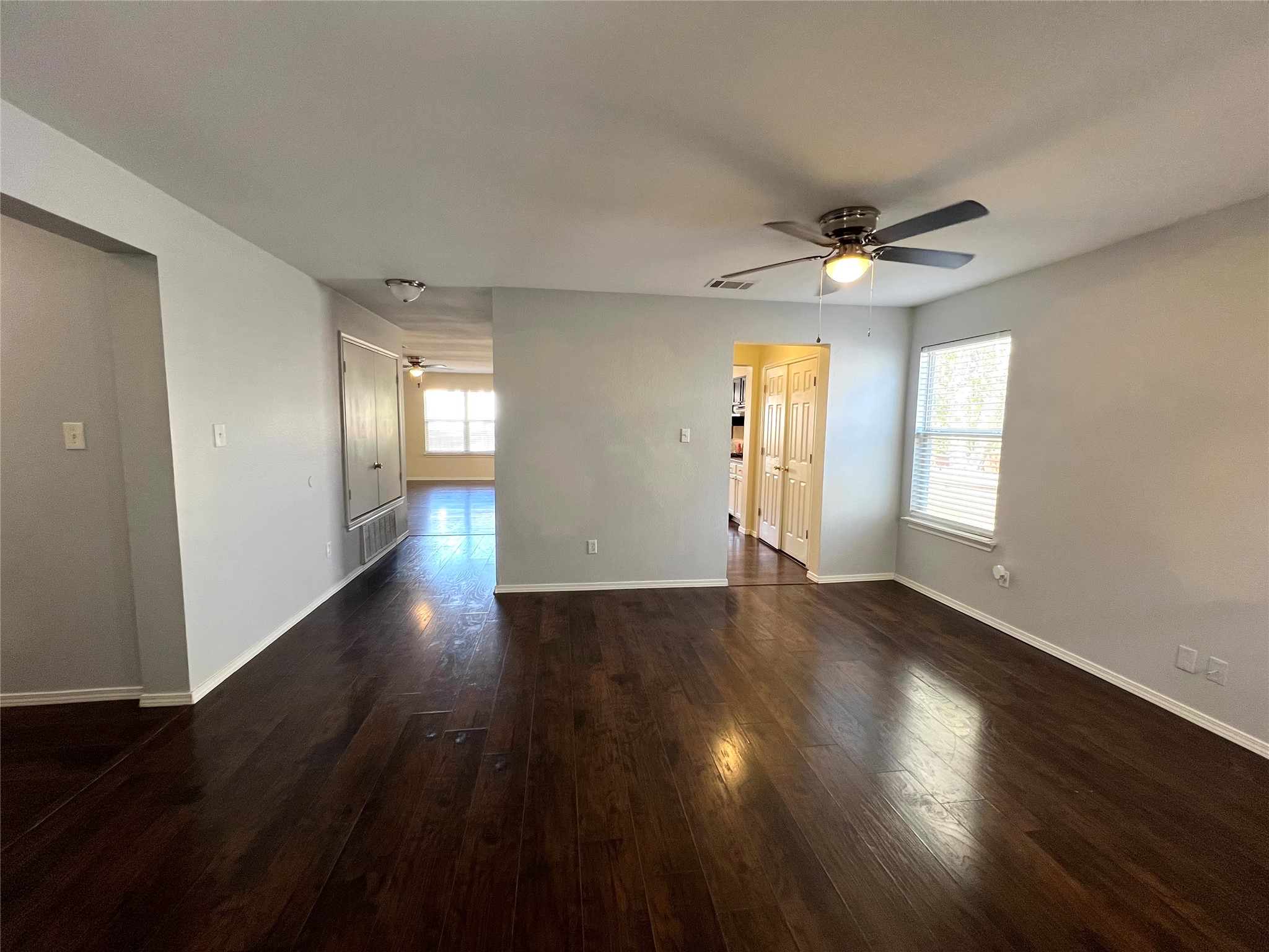 125 Dandelion Loop Kyle, TX 78640 - Photo 5 of 25 a view of an empty room with wooden floor and a window