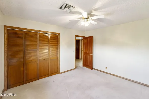 an empty room with fan and entryway
